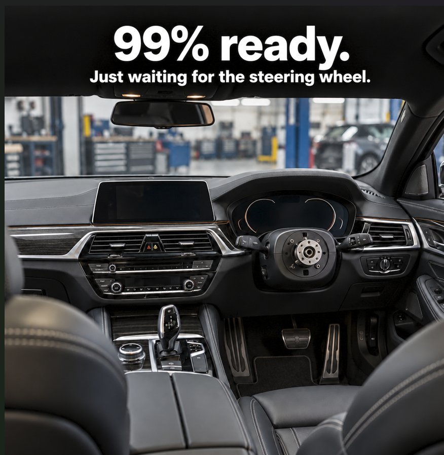 A car interior that looks finished and ready to drive, except the steering wheel is missing. Caption: 99% ready. Just waiting for the steering wheel.